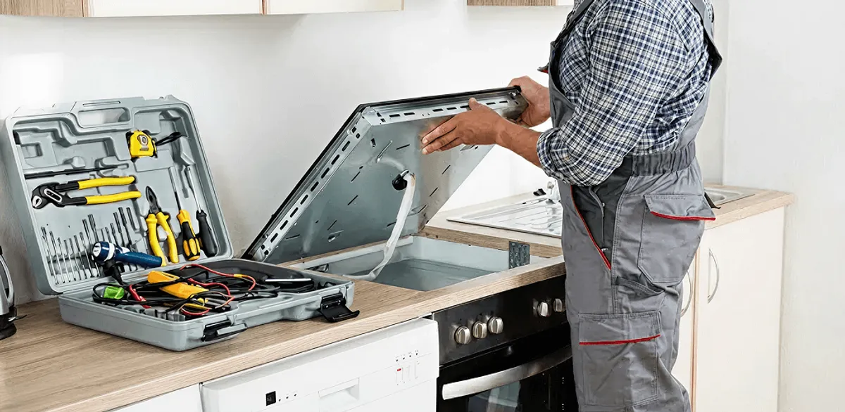 Handyman repairing a cooktop and checking wiring connections in Orange, CA