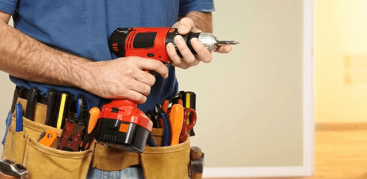 Handyman holding a power drill for home repairs and installations in Orange, CA